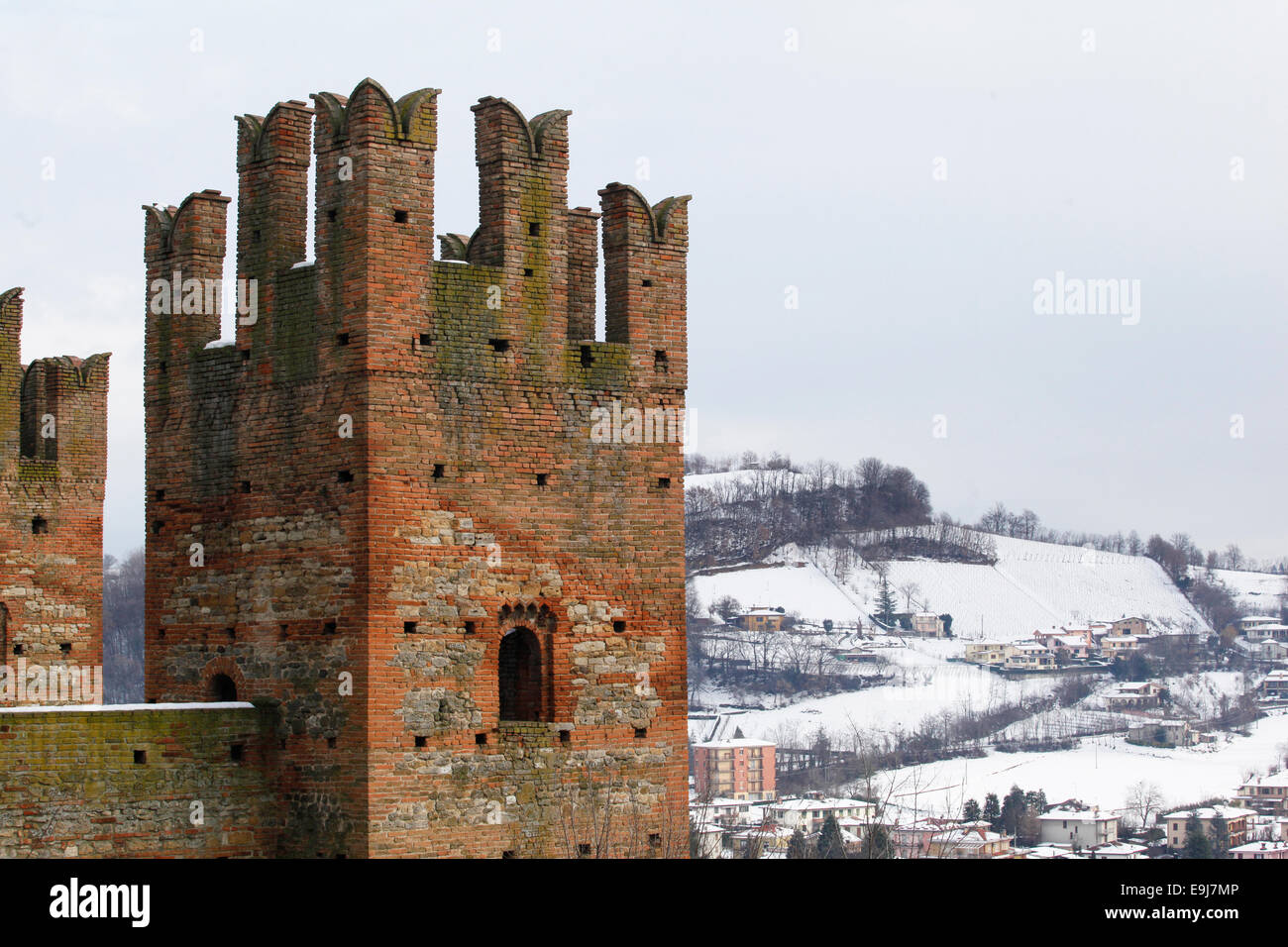 Una delle torri del Castell'Arquato del castello con le colline coperte da neve in background. Piacenza, Emilia Romagna, Italia. Foto Stock