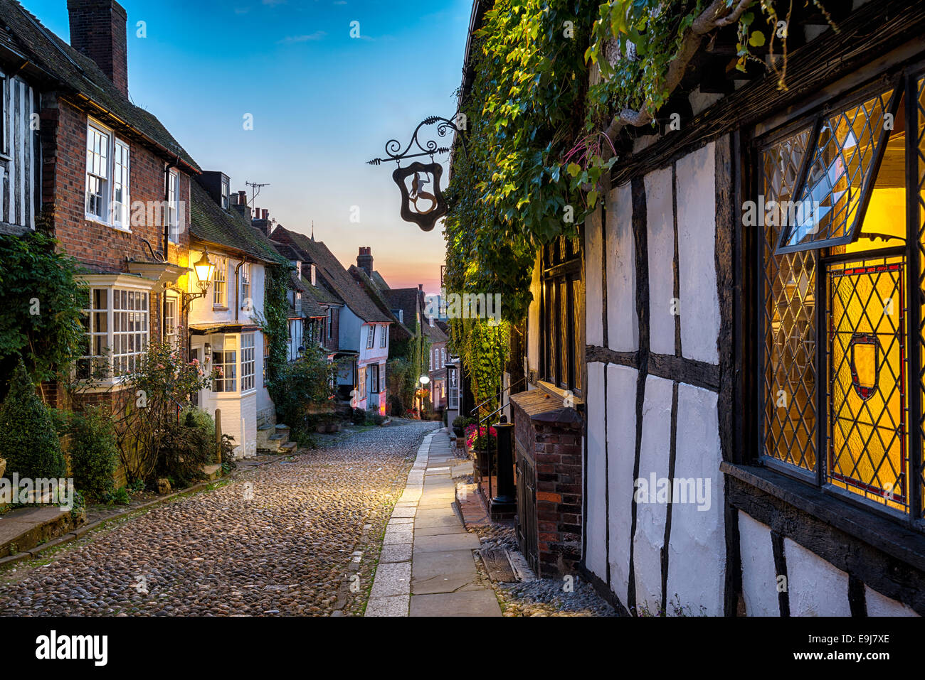 Crepuscolo in corrispondenza di una fila di belle vecchie case su una strada di ciottoli in segale, East Sussex Foto Stock