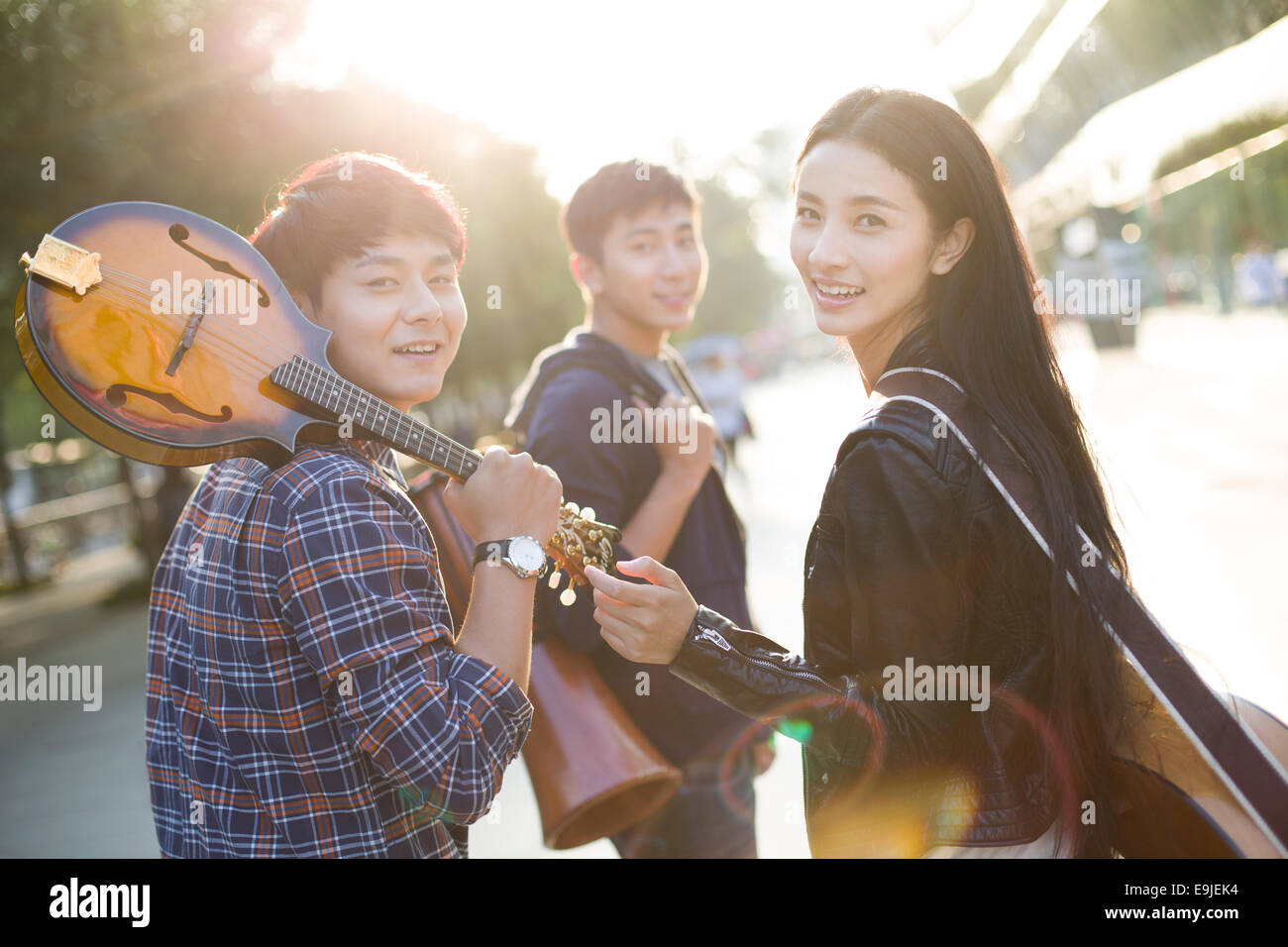 I giovani adulti con attrezzature musicali lasciando Foto Stock