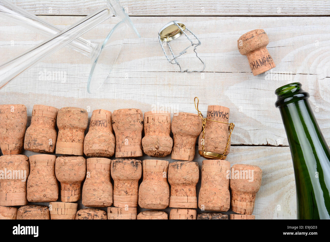 Alta angolazione di un vuoto bottiglia di champagne con tappi di sughero e di due scanalature. Primo piano su un rustico di legno bianco tavola. Formato orizzontale. Foto Stock