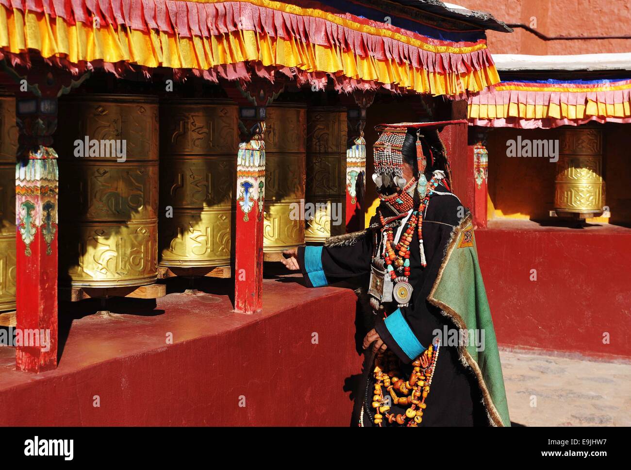 (141029) -- BURANG, Ottobre 29, 2014 (Xinhua) -- una donna che indossa il costume Burang ruotare le ruote di preghiera al villaggio Kegya Burang nella contea di Nagri Prefettura, a sud-ovest della Cina di regione autonoma del Tibet, Ottobre 23, 2014. Burang costume che ha una storia di più di mille anni, è famoso per i suoi lussuosi accessori. Centinaia di pezzi di cera d'api, numerose perle e kallaties, ammassata coralli rossi e delicato argento e decori in oro comporre di inestimabile suite. Sette famiglie a Kegya villaggio hanno conservato sette tute di costumi Burang tramandata dagli antenati. (Xinhua/Wen Tao) (lfj) Foto Stock