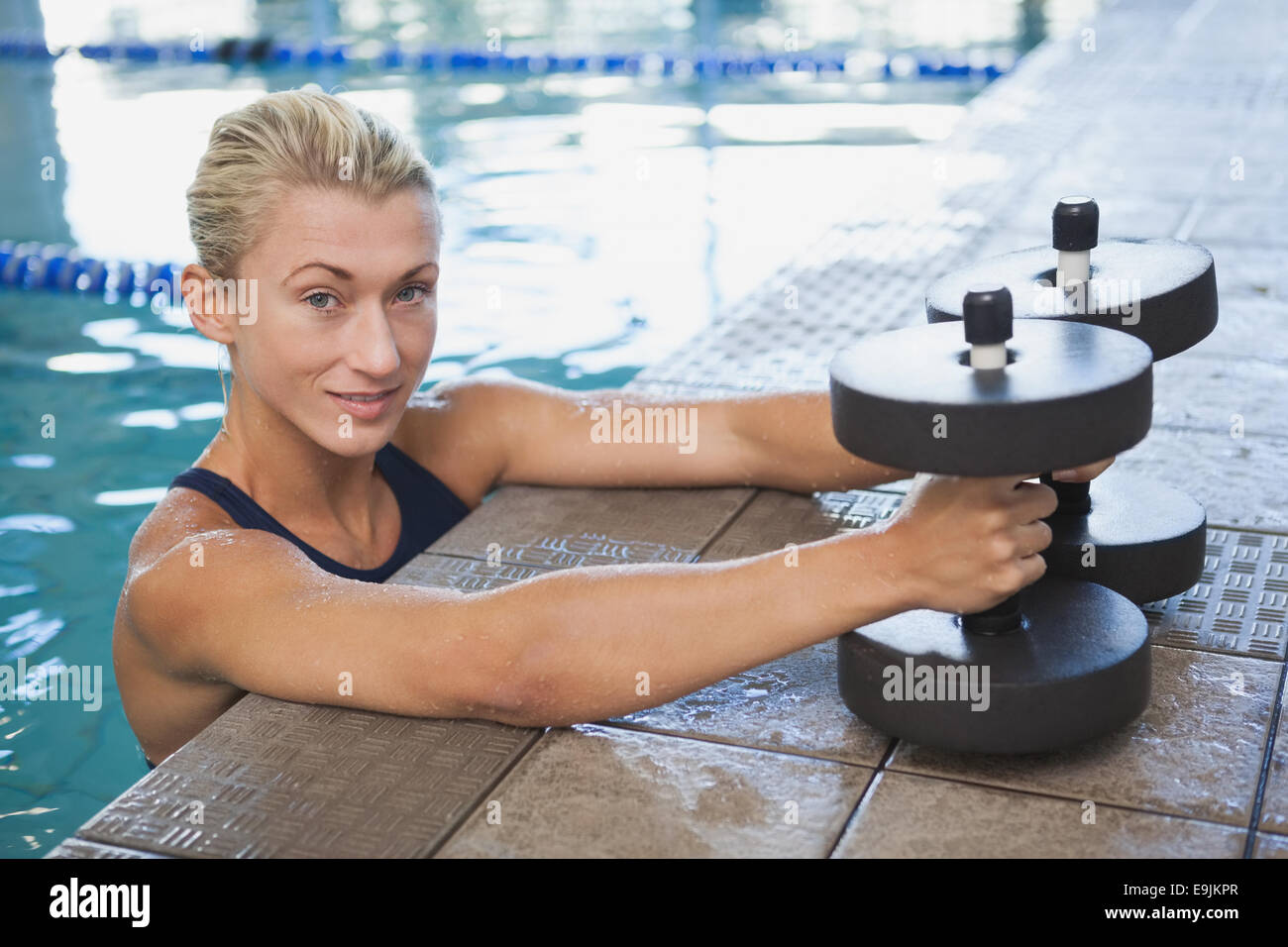 Nuotatore femmina con schiuma manubri in piscina Foto Stock