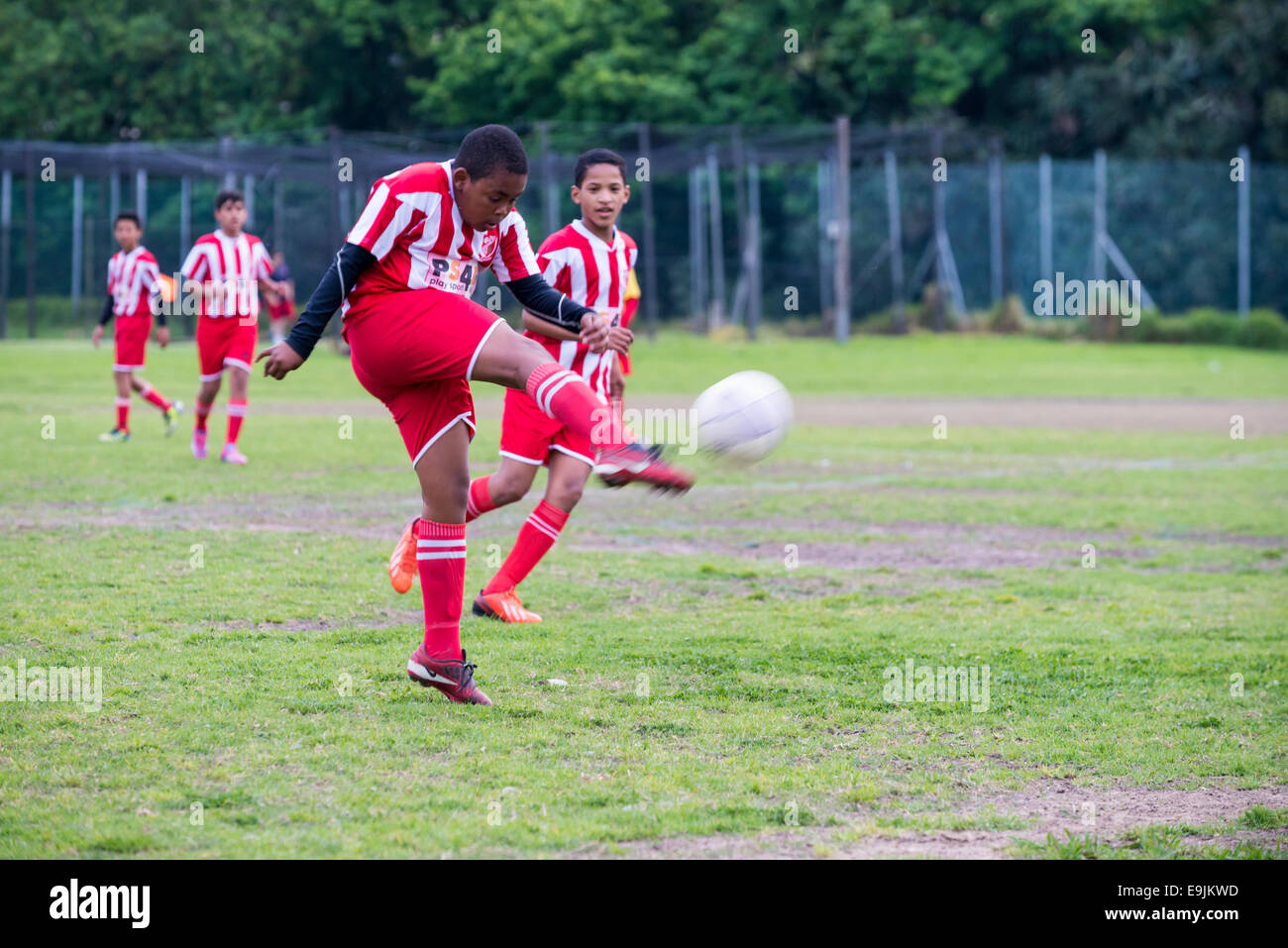 Il calcio giovanile player U13 dà dei calci alla sfera volley, Cape Town, Sud Africa Foto Stock