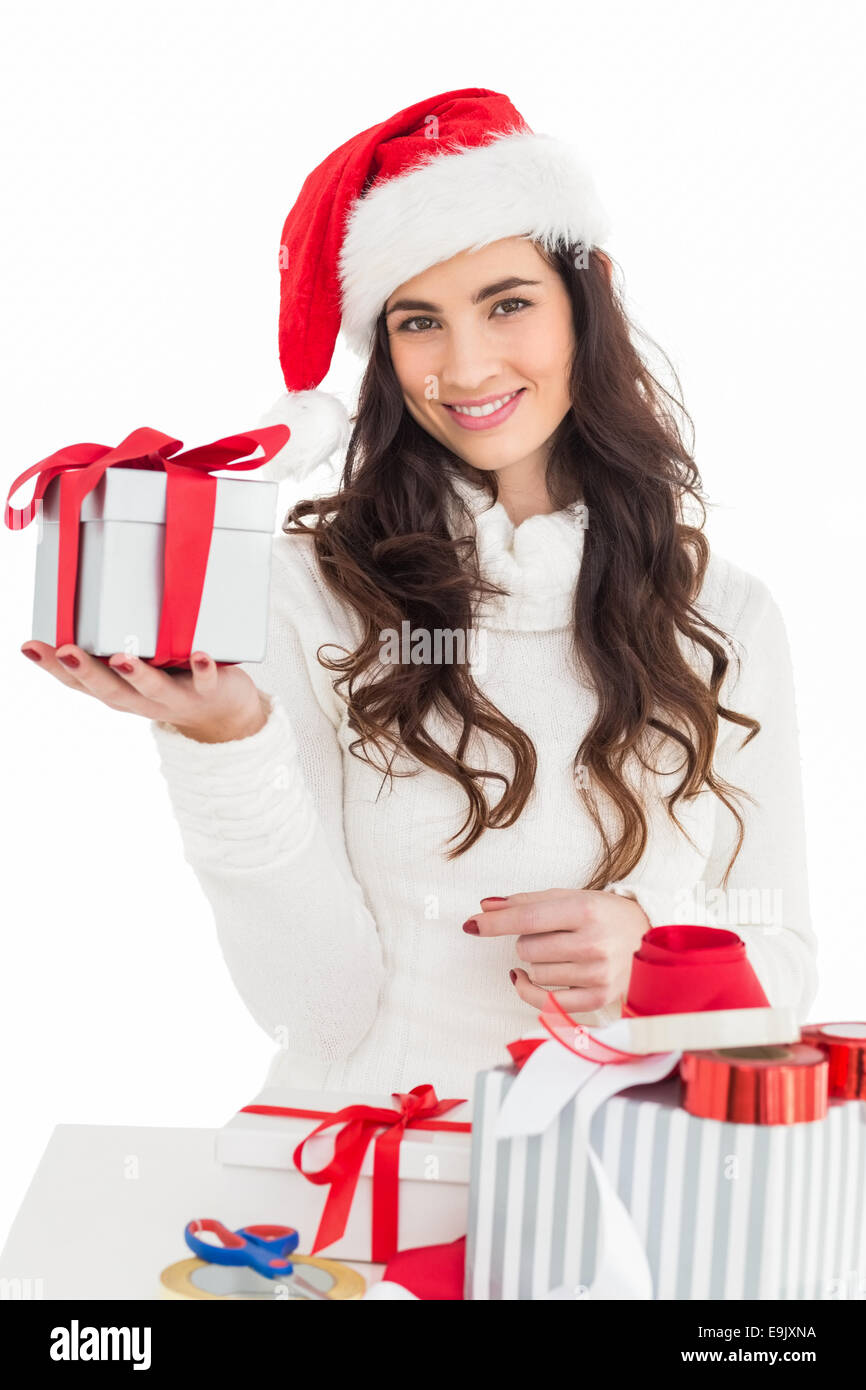 Allegro brunette in santa hat holding dono Foto Stock