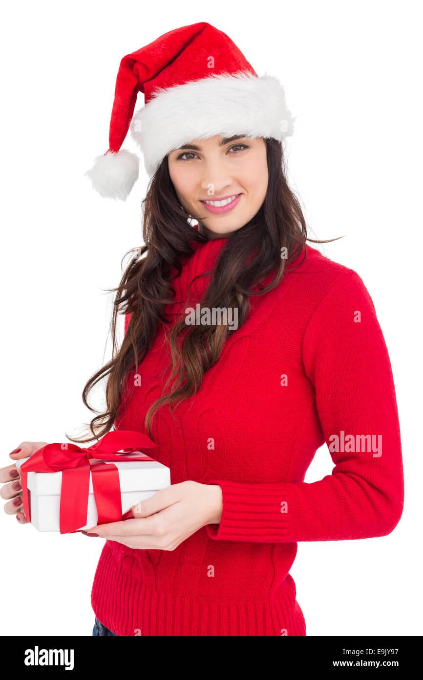 Sorridente brunette in santa hat tenendo un dono Foto Stock