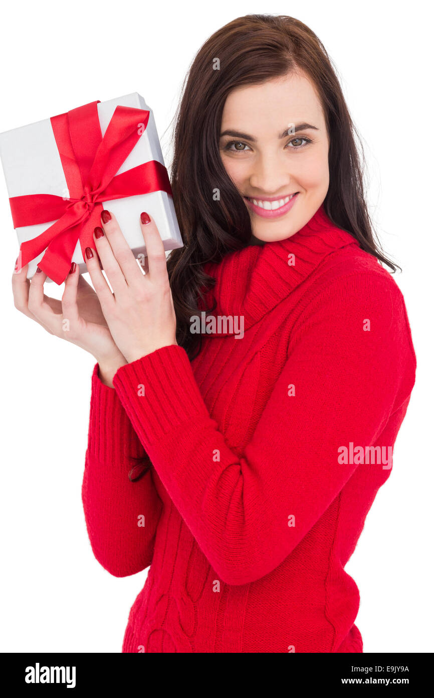 Sorridente brunette nel ponticello di Red Hat che mostra un regalo Foto Stock