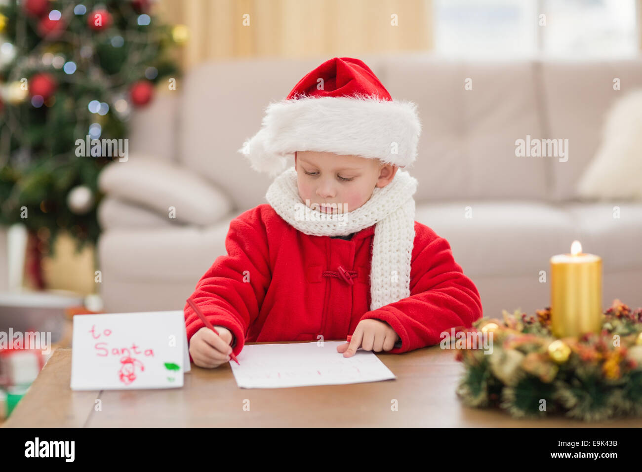 Festive little boy iscritto la lista dei desideri Foto Stock