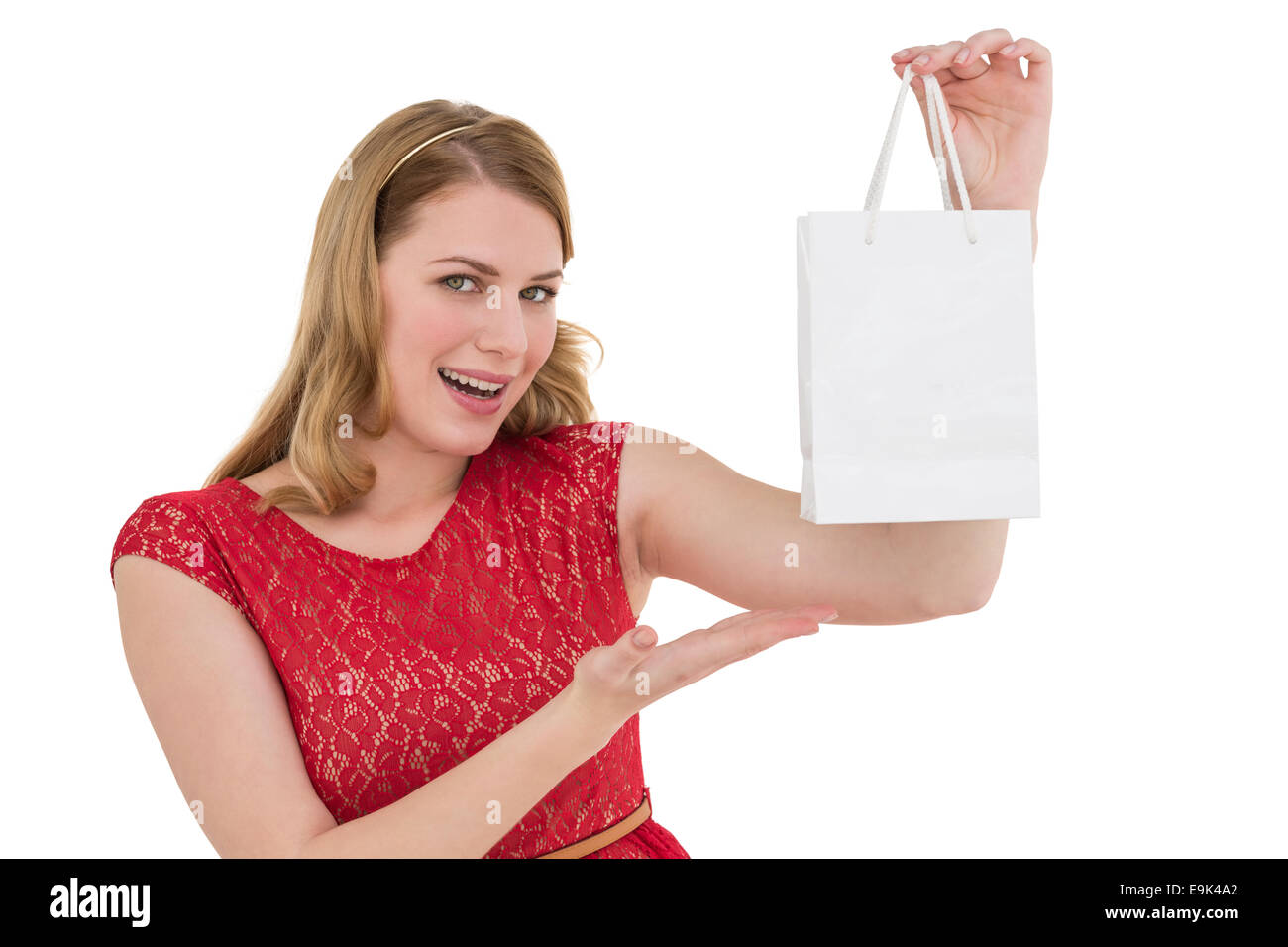 Donna sorridente presentando una borsa per la spesa Foto Stock