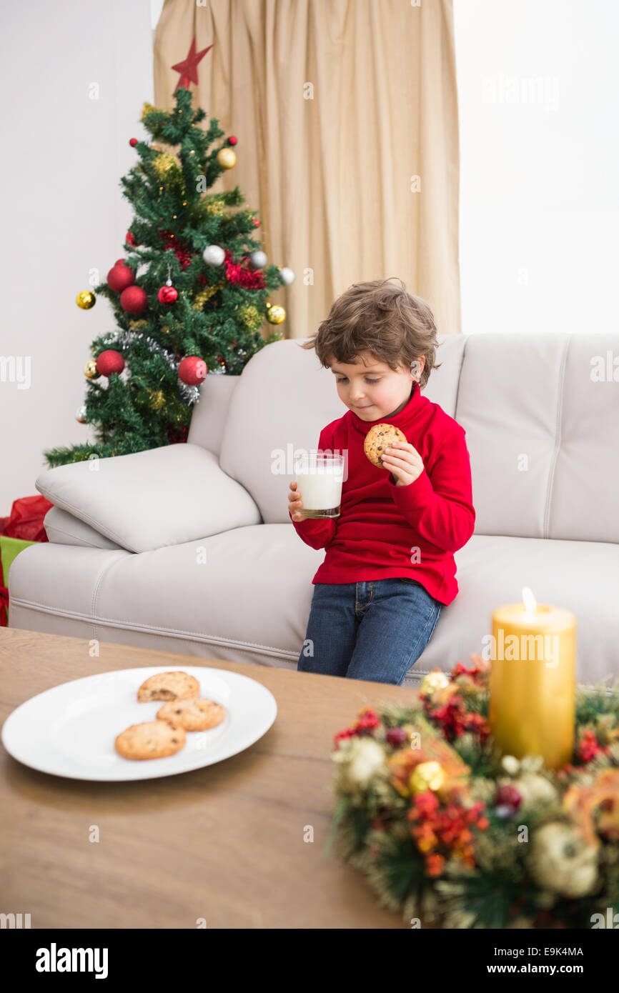 Festive little boy avente latte e biscotti Foto Stock