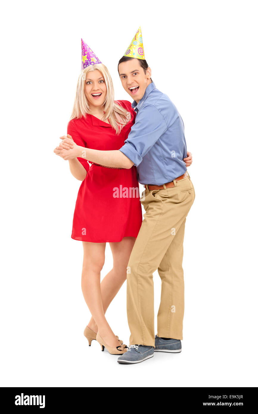 A piena lunghezza Ritratto di una giovane coppia con party cappelli dancing isolati su sfondo bianco Foto Stock