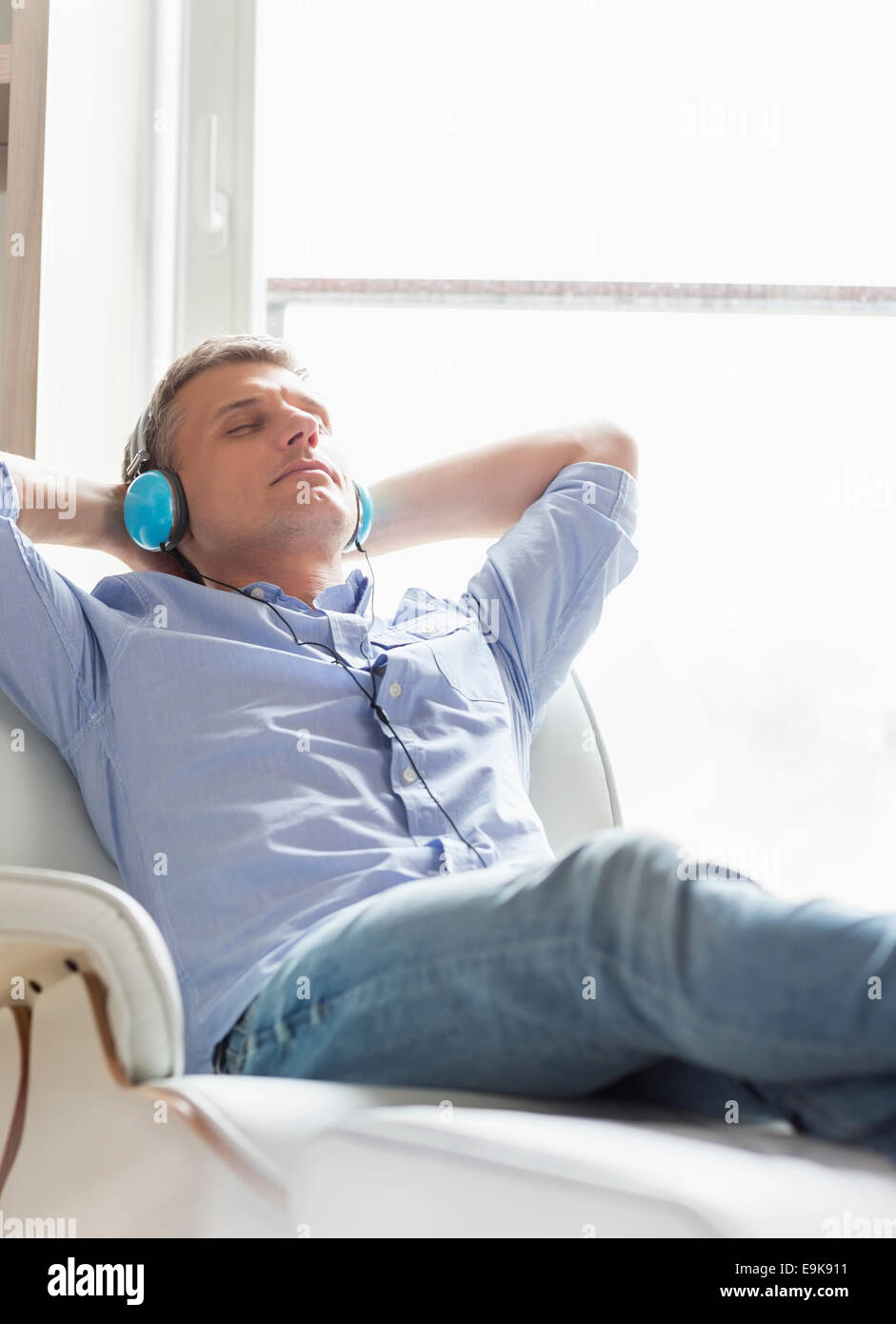 Rilassata uomo di mezza età ascoltando la musica a casa Foto Stock