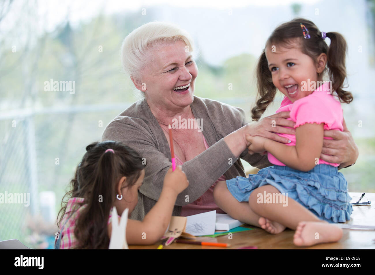 Felice senior donna avente il tempo di qualità con nipoti a casa Foto Stock