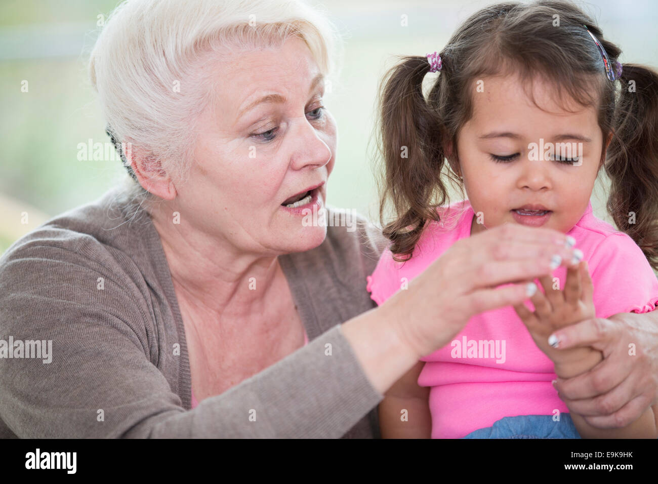 Senior donna aiutando la nipote di contare le dita a casa Foto Stock