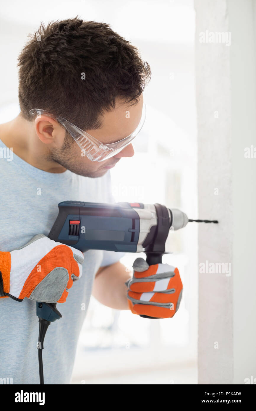 Metà di uomo adulto la perforazione nella parete Foto Stock