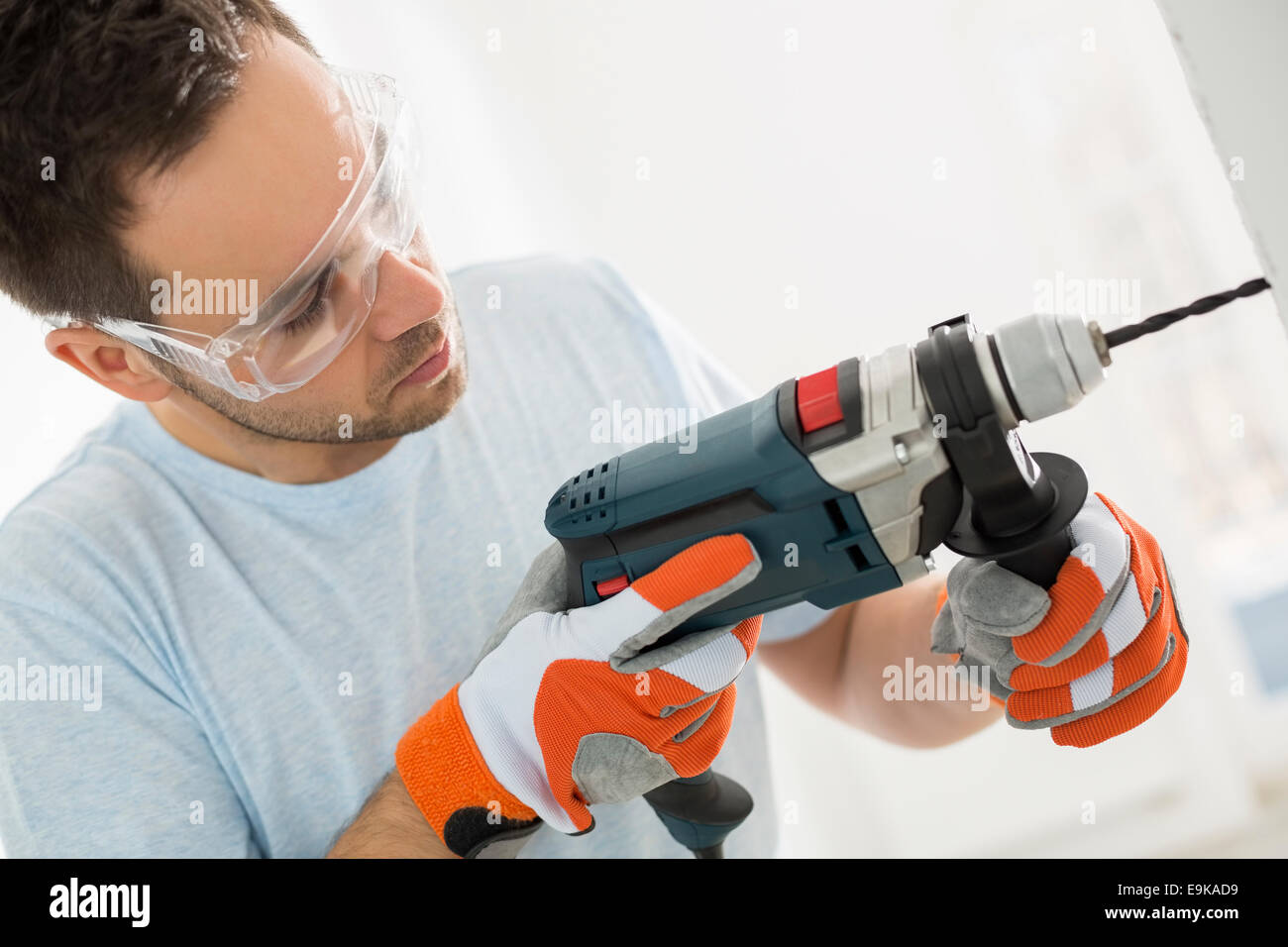 Metà di uomo adulto la perforazione nella parete Foto Stock