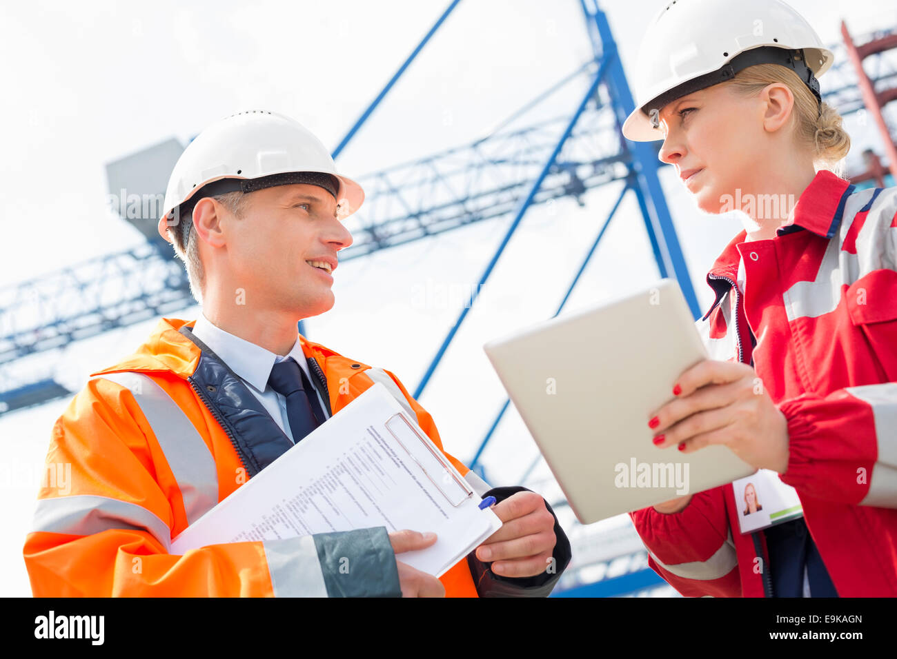 Lavoratori a discutere su computer tablet in cantiere di spedizione Foto Stock