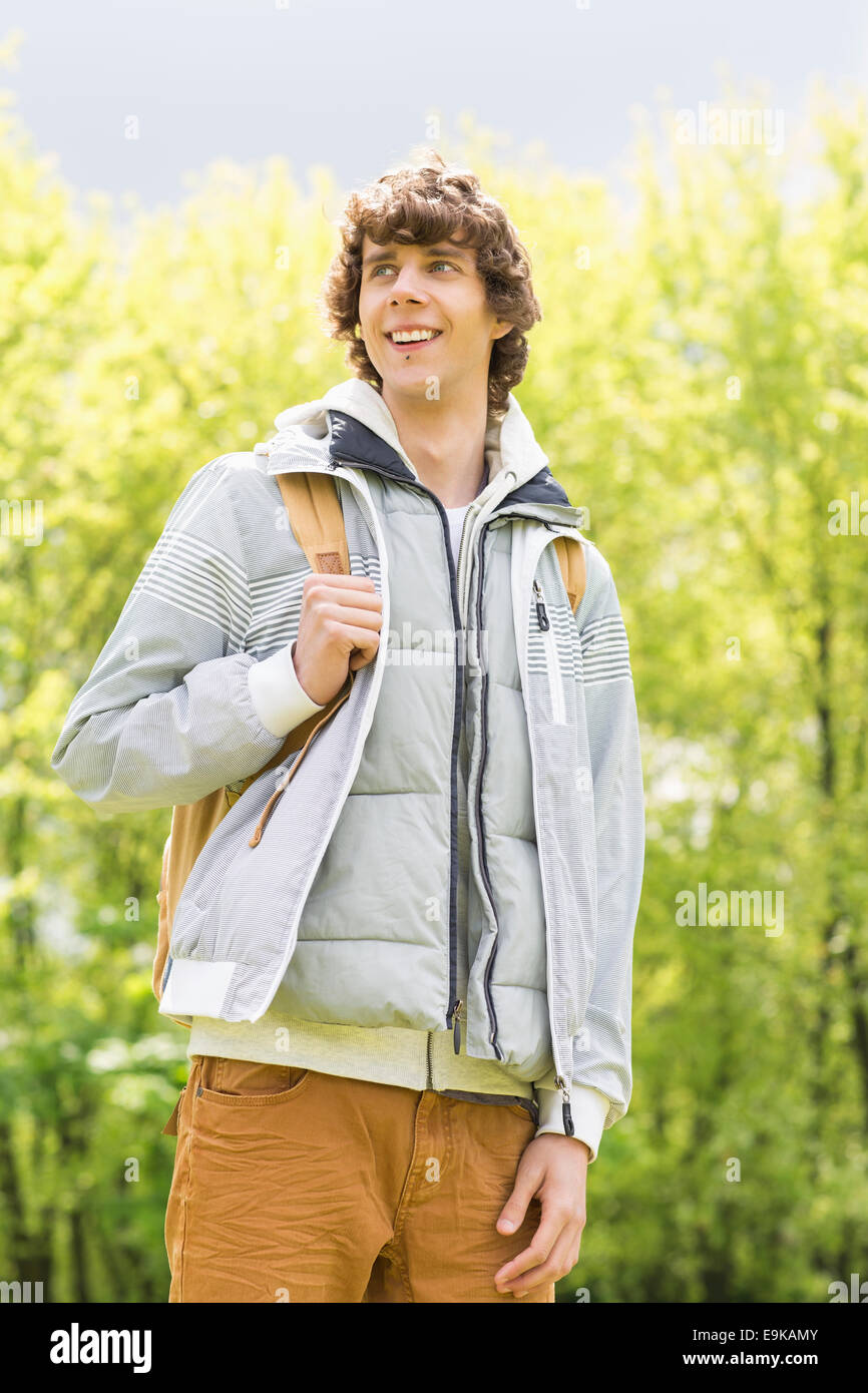 Giovane uomo con zaino permanente al campus universitario Foto Stock