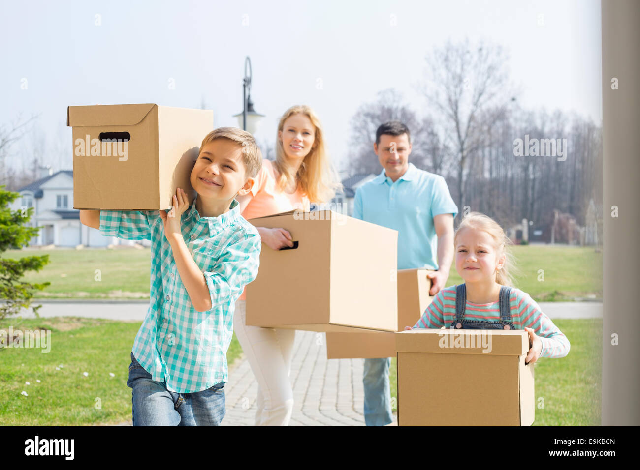 Famiglia con scatole di cartone in movimento nella nuova casa Foto Stock