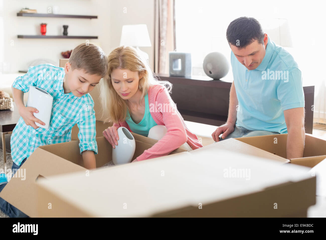Disimballaggio della famiglia di scatole di cartone in casa nuova Foto Stock