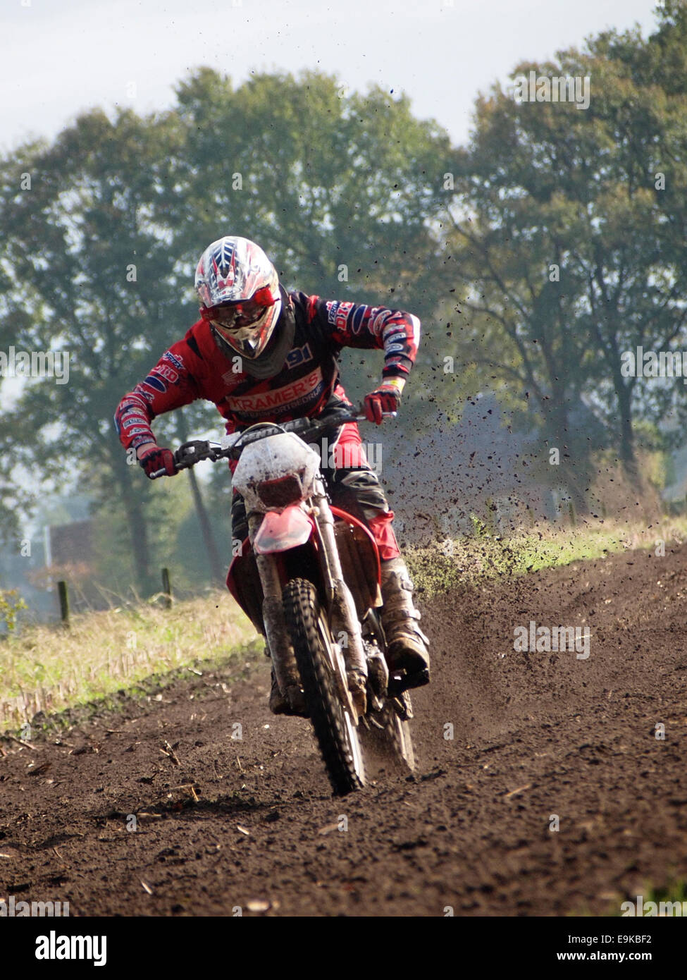 Honda cross motociclista a cavallo attraverso il campo di vista anteriore, Ruurlo, Paesi Bassi Foto Stock