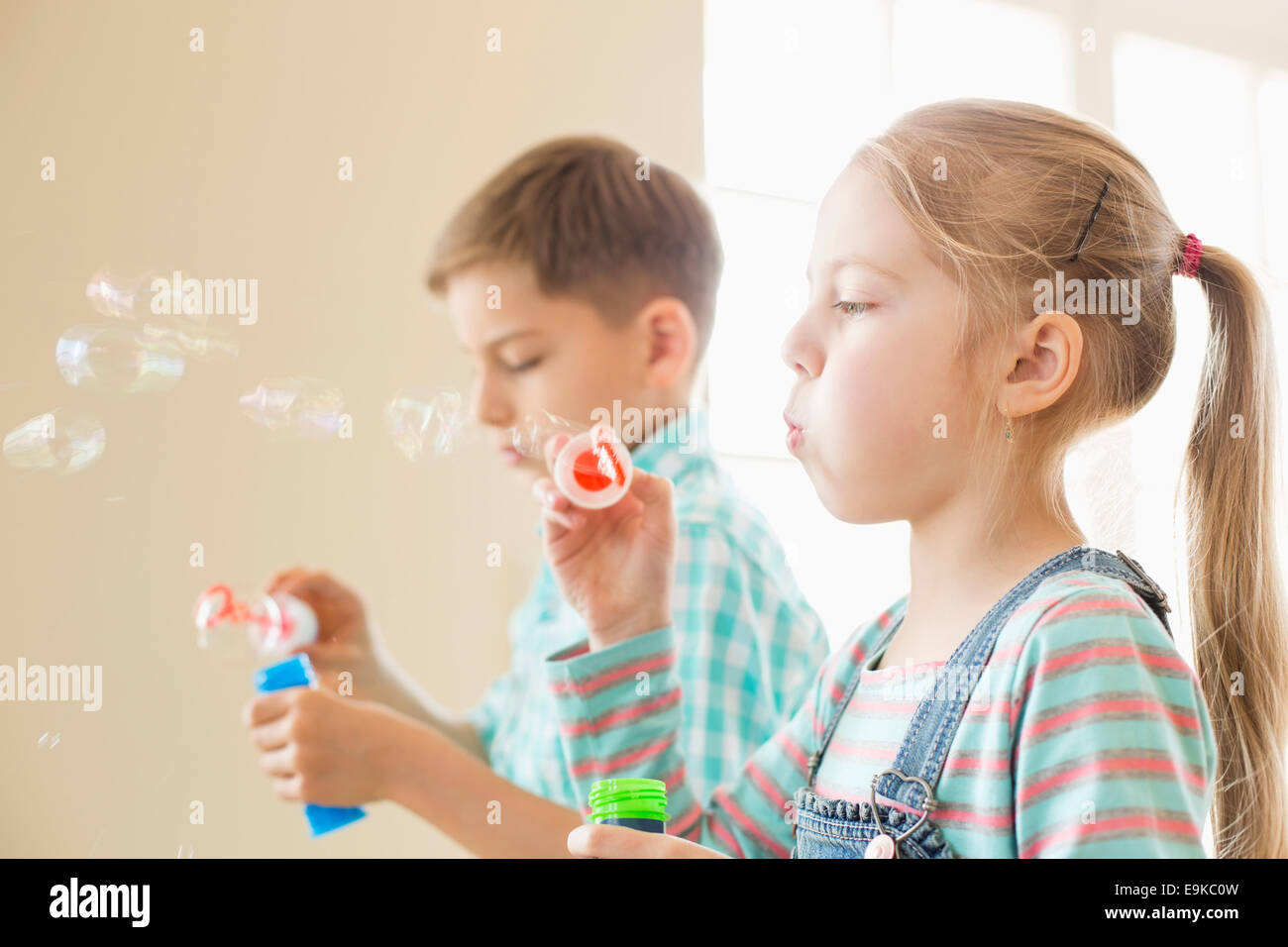 Fratello e Sorella gioca con bacchette di bolle a casa Foto Stock
