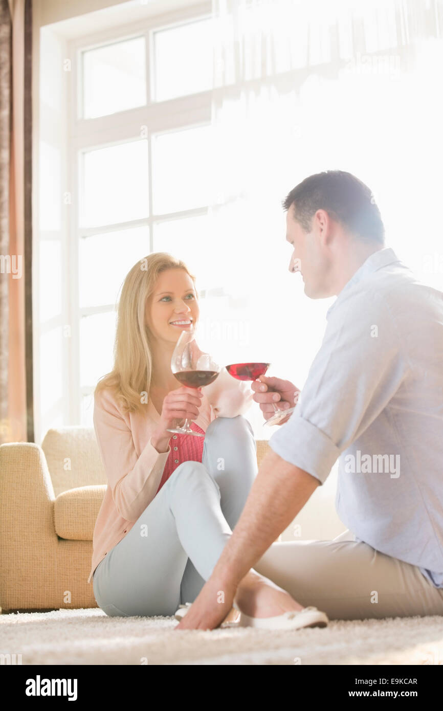 Coppia felice guardando ogni altra pur avendo il vino rosso a casa Foto Stock