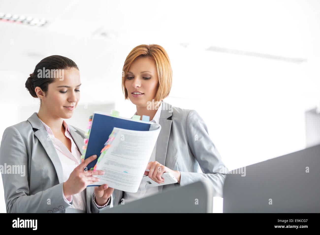 Giovani imprenditrici discutendo sul libro in office Foto Stock