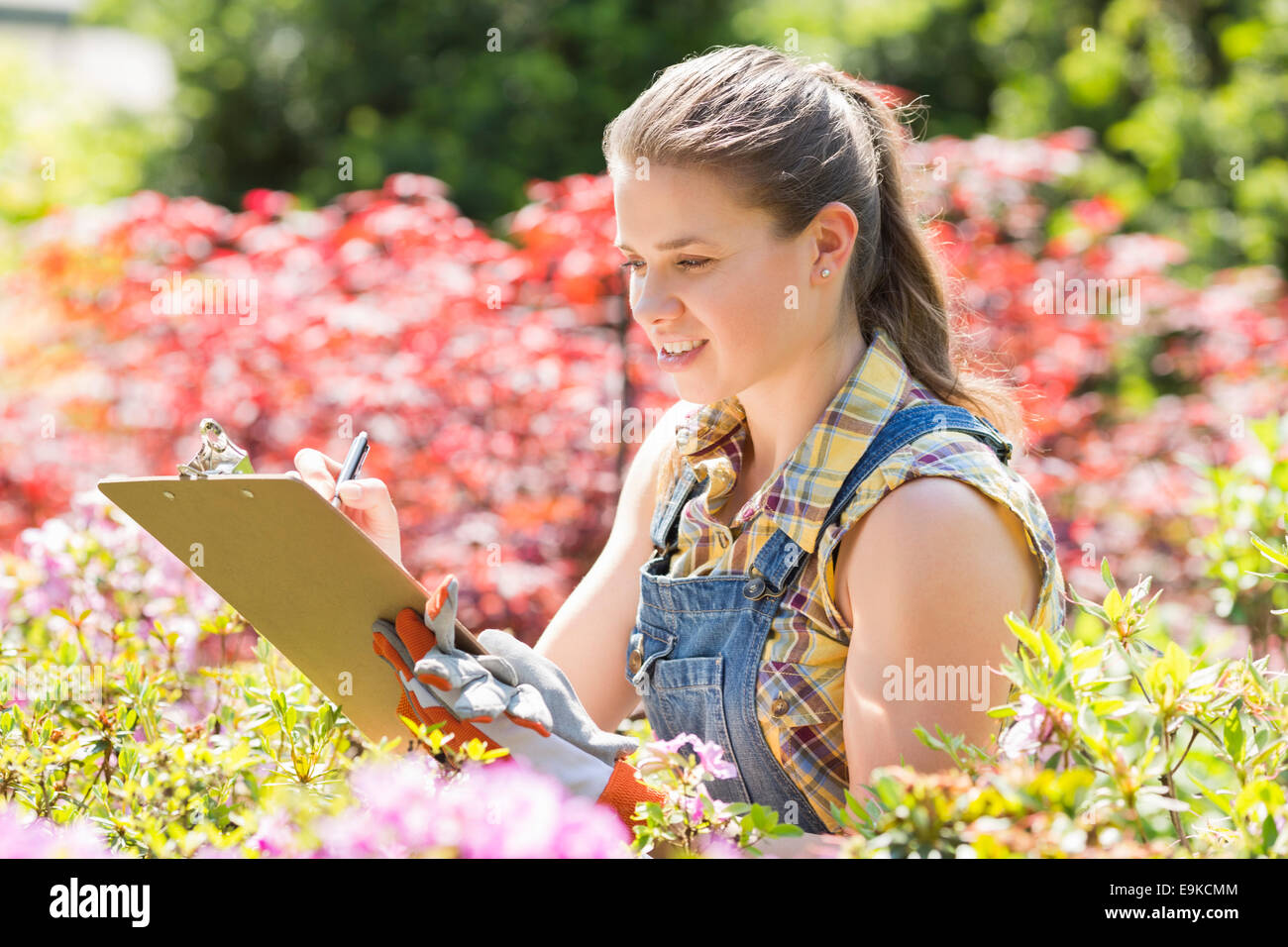 Supervisore femmina iscritto negli appunti in giardino Foto Stock