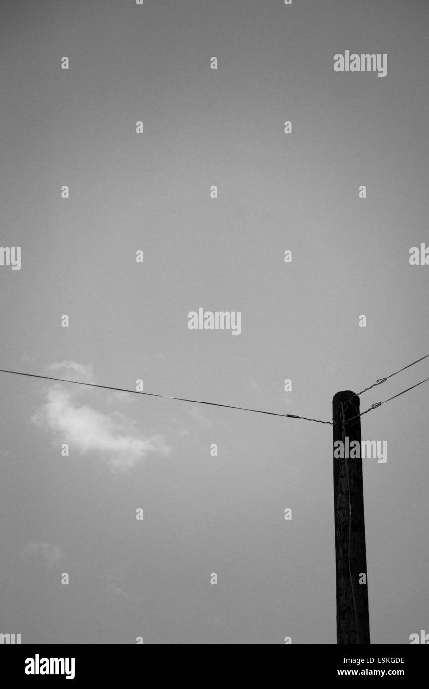 Vecchio palo telefonico e sky in tranquilla zona rurale Foto Stock