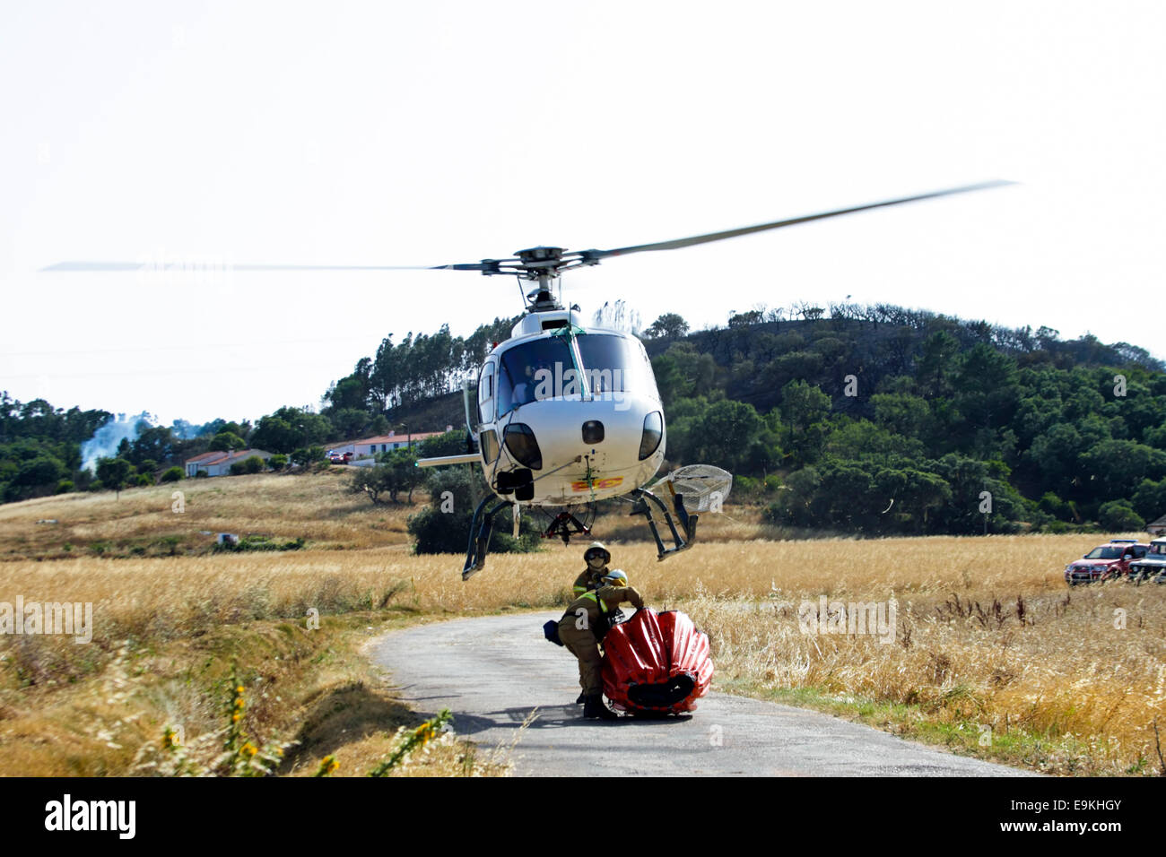 I vigili del fuoco lottano contro il fuoco con un elicottero in campagna dal Portogallo Foto Stock