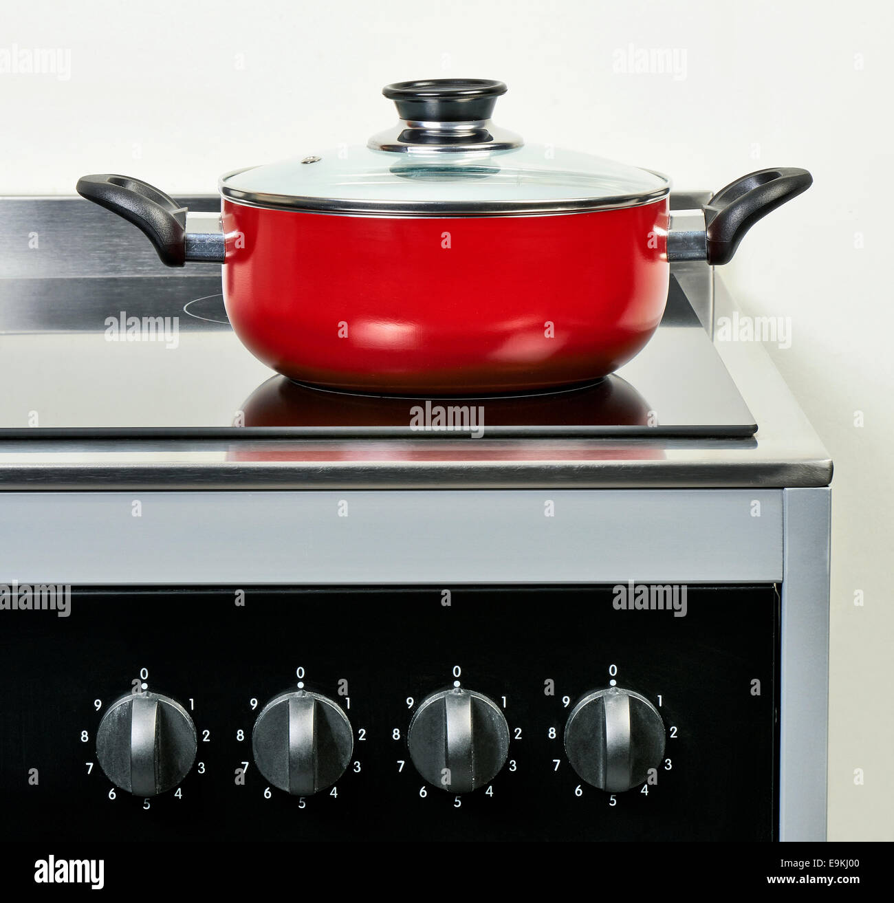 Rosso coppa in ceramica con coperchio sul piano di cottura elettrico in moderno e la cucina domestica Foto Stock