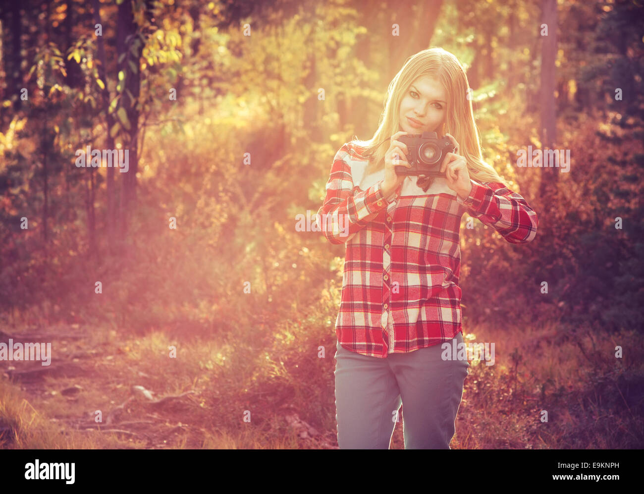 Giovane donna a piedi con retrò fotocamera foto Outdoor Lifestyle Travel sunny foresta sullo sfondo Foto Stock