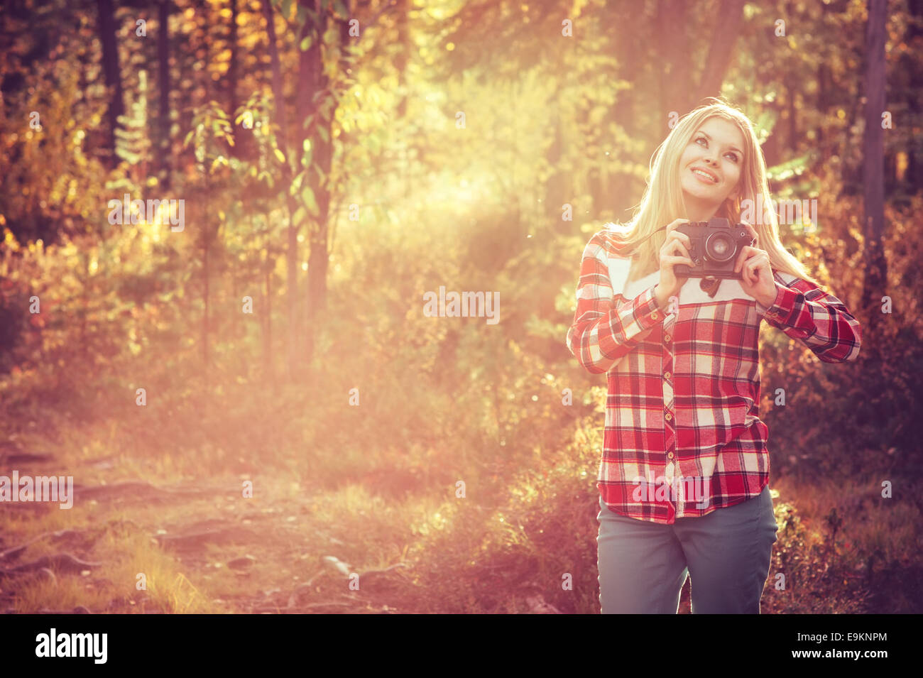 Giovane donna a piedi con retrò fotocamera foto Outdoor Lifestyle Travel sunny foresta sullo sfondo Foto Stock