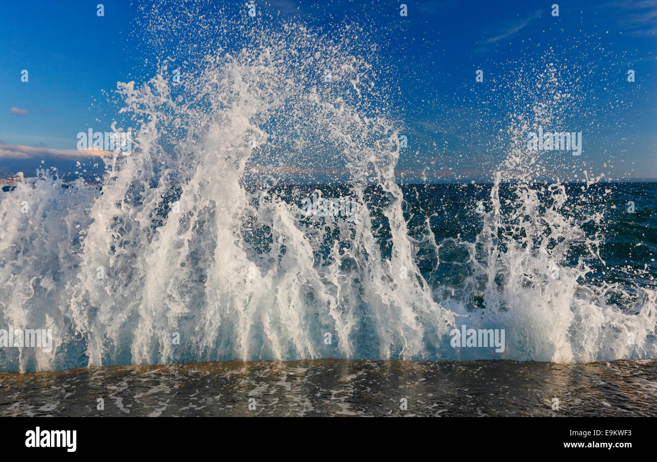 Le onde del mare gli spruzzi di roccia sulla spiaggia Foto Stock
