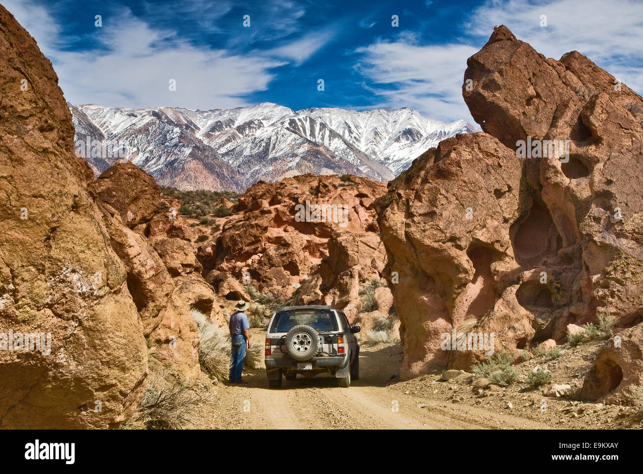 Visitatori e 4WD veicolo su strada nel Red Rock Canyon, White Mountains in Distance, Mojave Desert vicino a Bishop, California, USA Foto Stock
