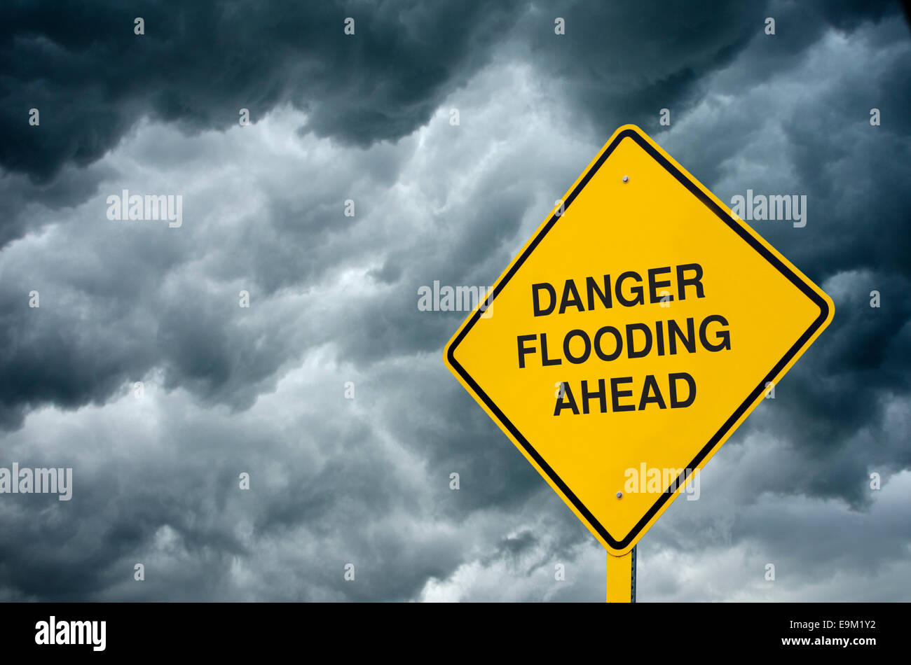 Inondazioni in anticipo cartello stradale: un segno di attenzione nella parte anteriore delle nubi di avvertimento "pericolo inondazioni a venire". Foto Stock