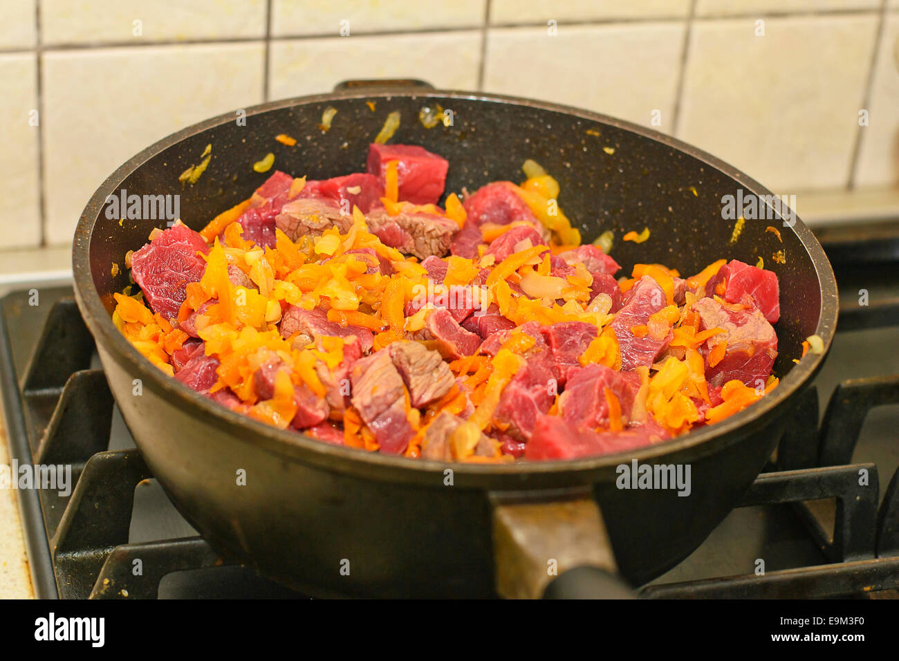 La cottura della carne in padella con verdure. Foto Stock