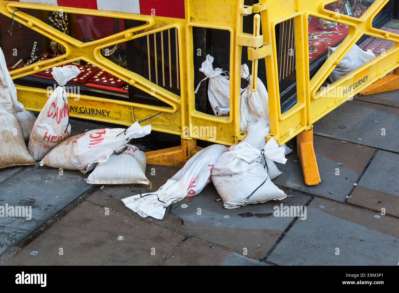 Le barriere in plastica e sacchi di sabbia in appoggio contro un negozio di fronte all indomani delle inondazioni. Foto Stock