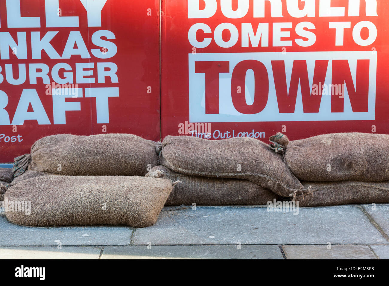 Sacchi di sabbia in appoggio contro un negozio porta in preparazione contro le inondazioni. Foto Stock
