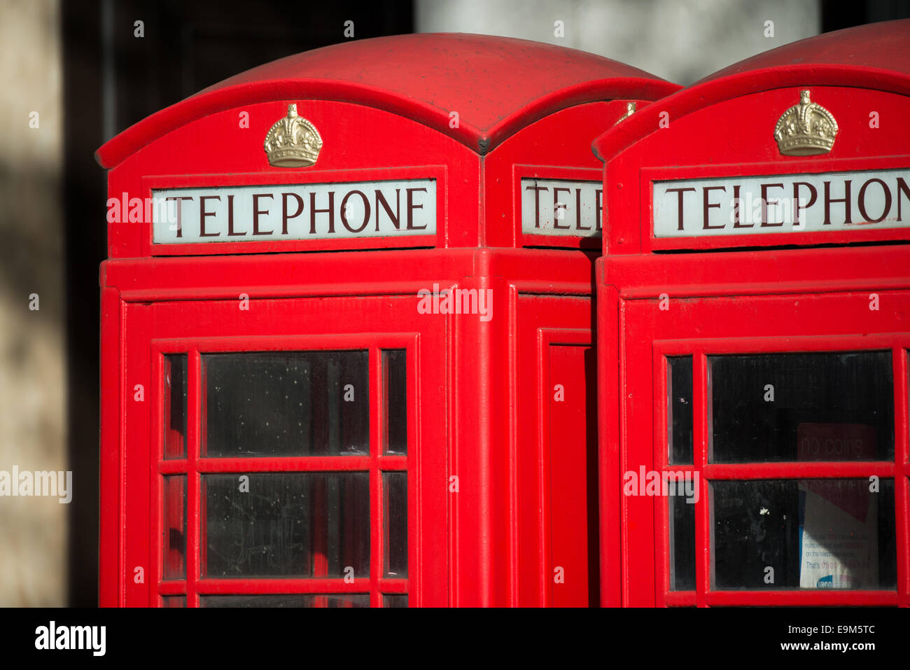 Red Telephone Box Londra Regno Unito | LONDRA, Regno Unito — tetti a cupola e corone in rilievo Tudor in cima a una fila di chioschi telefonici rossi, molto probabilmente il modello K6 progettato da Sir Giles Gilbert Scott. Introdotto nel 1935 per celebrare il giubileo d'argento di re Giorgio V, il K6 divenne lo standard nazionale l'anno successivo, con più di 65.000 esemplari alla fine prodotti. La corona è il cifrario reale dell'Ufficio postale generale. Foto Stock