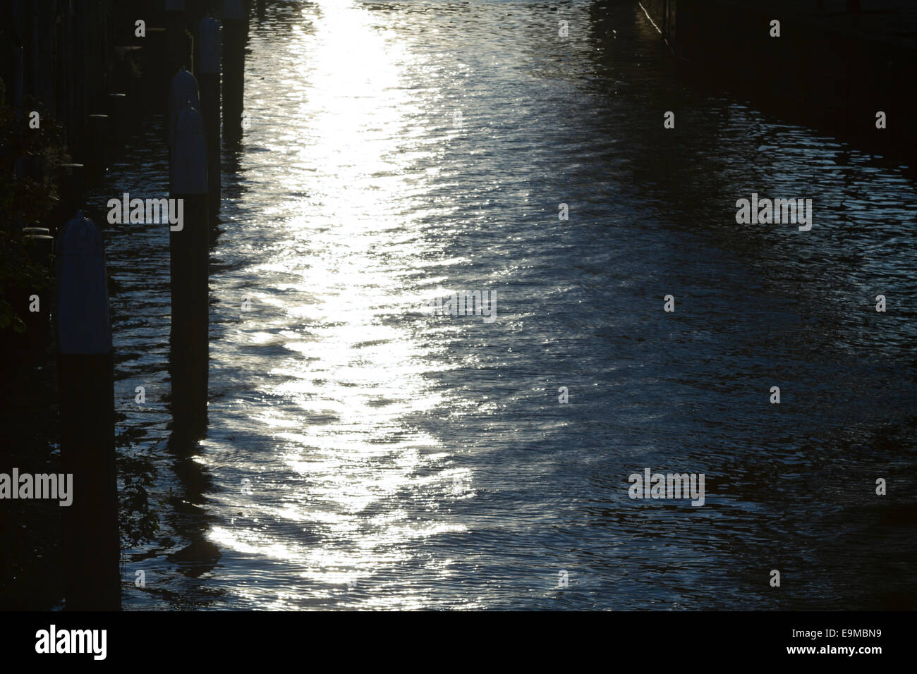 Luminosi riflessi sull'acqua come il sole tramonta Foto Stock