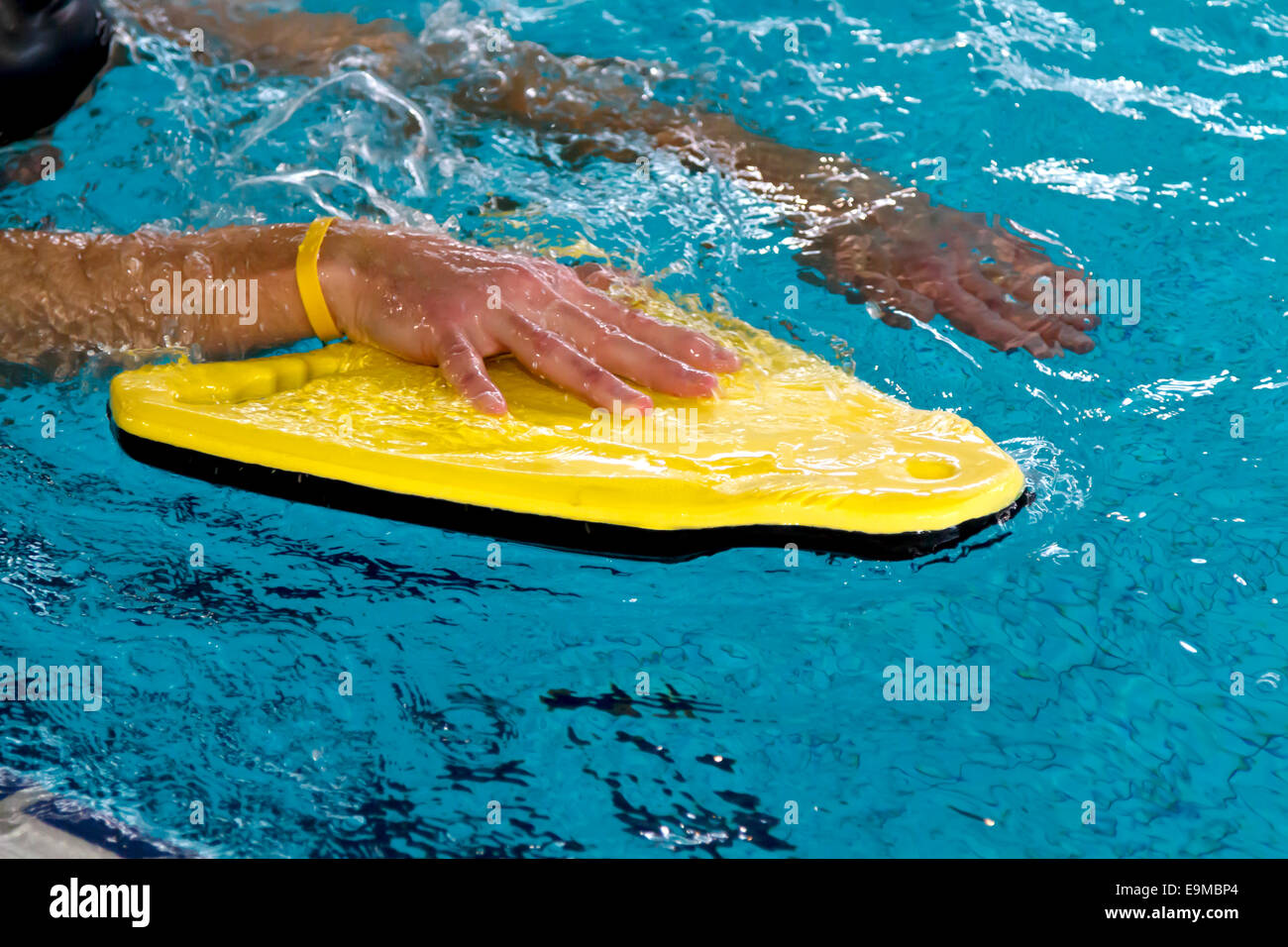 Uomo in piscina utilizzando una boa di colore giallo di treno in nuoto techniek Foto Stock