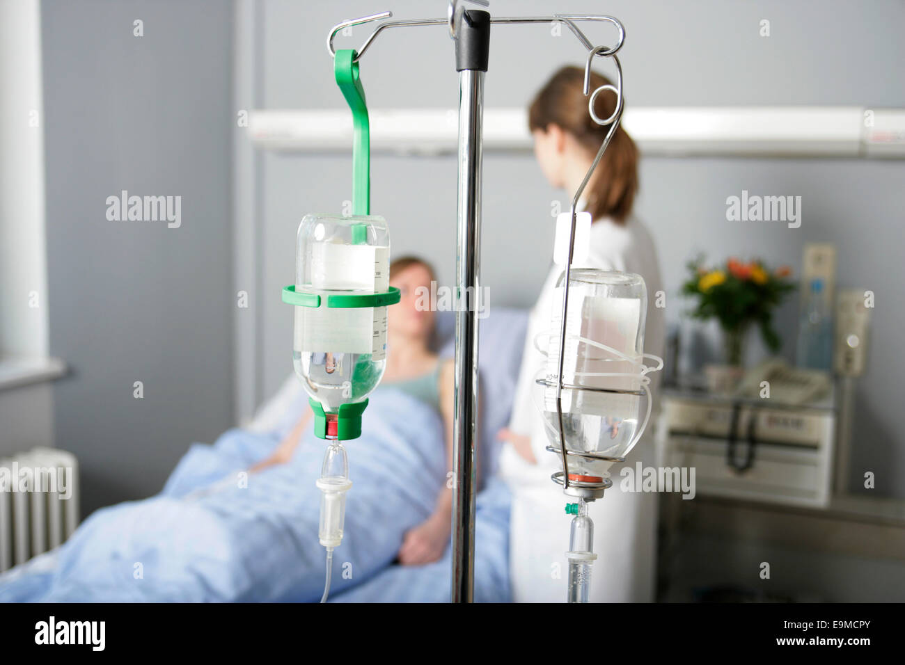 Close-up di flebo IV con il paziente e il medico in background Foto Stock