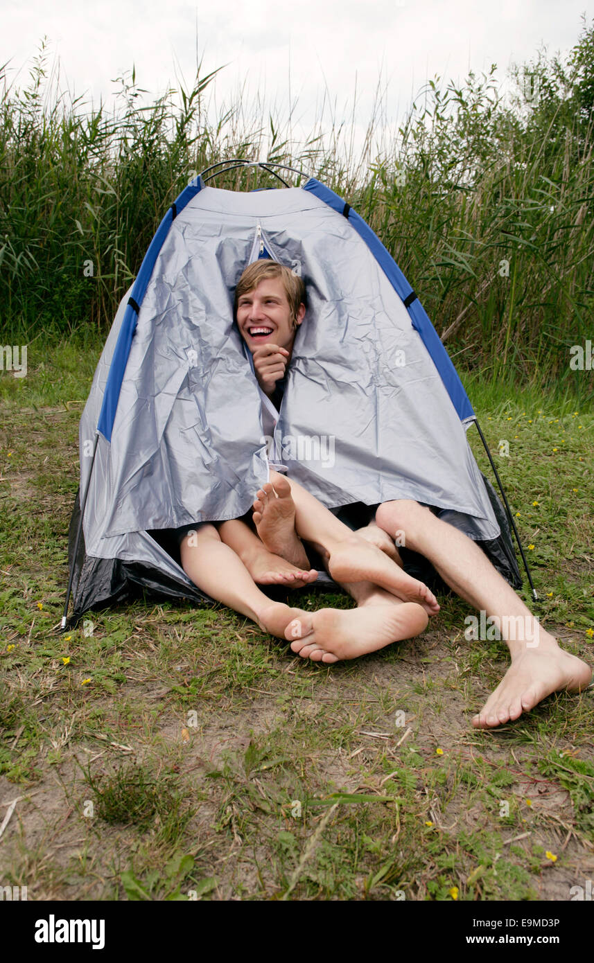 Tre persone che condividono una tenda Foto Stock