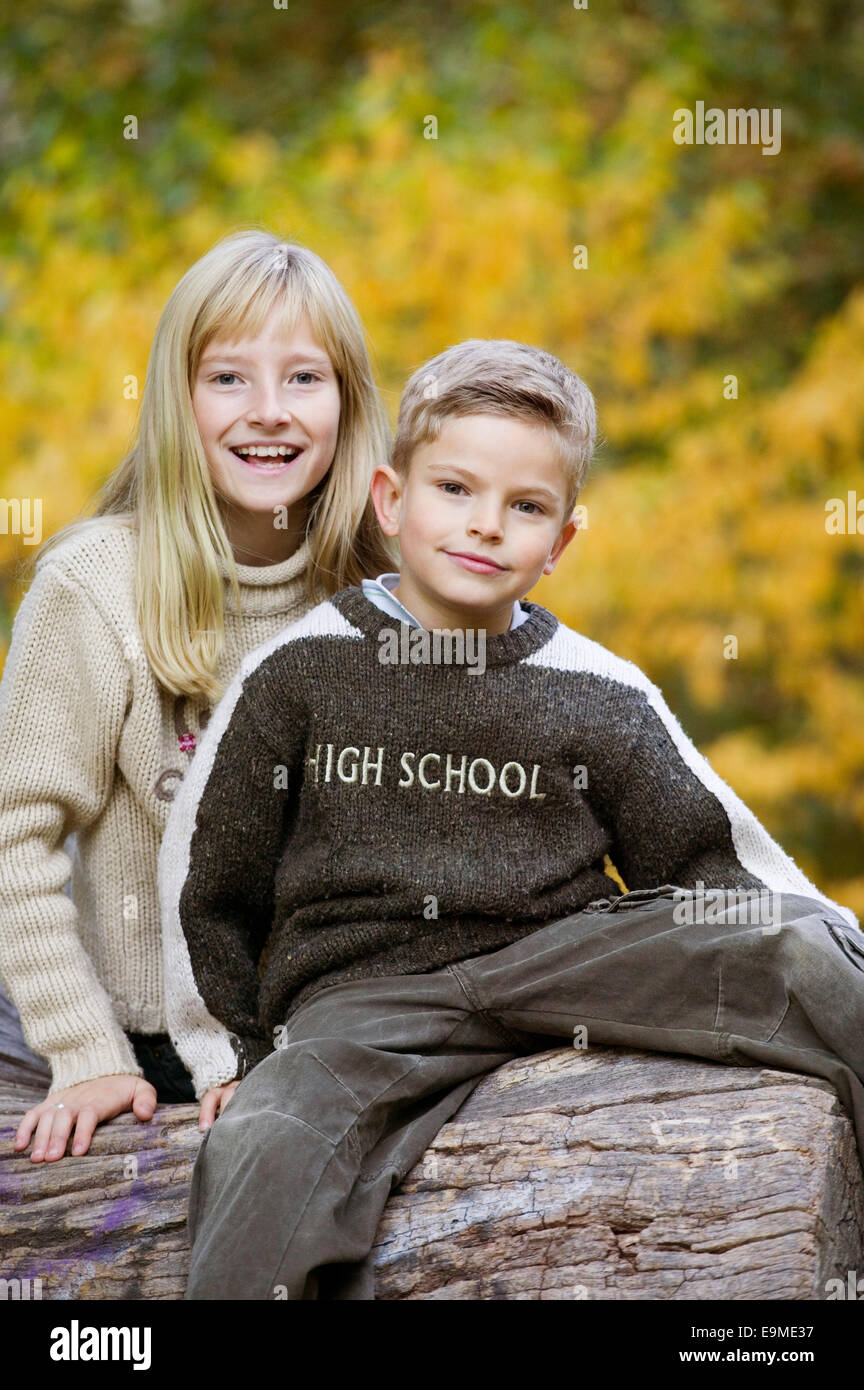 Un ragazzo e una ragazza insieme sul log di boschi Foto Stock