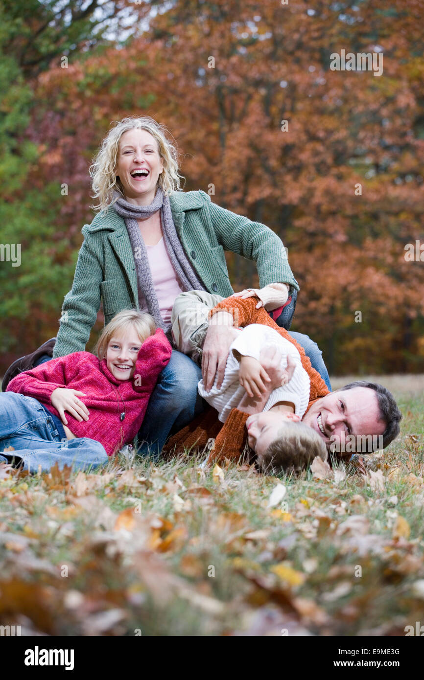 Famiglia di quattro wrestling nel parco Foto Stock