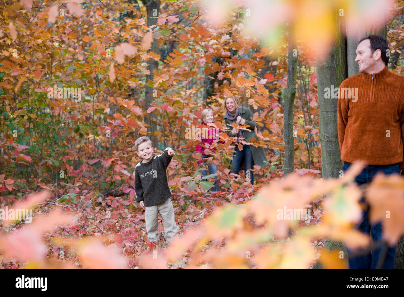 Famiglia di quattro persone di giocare a nascondino nei boschi Foto Stock