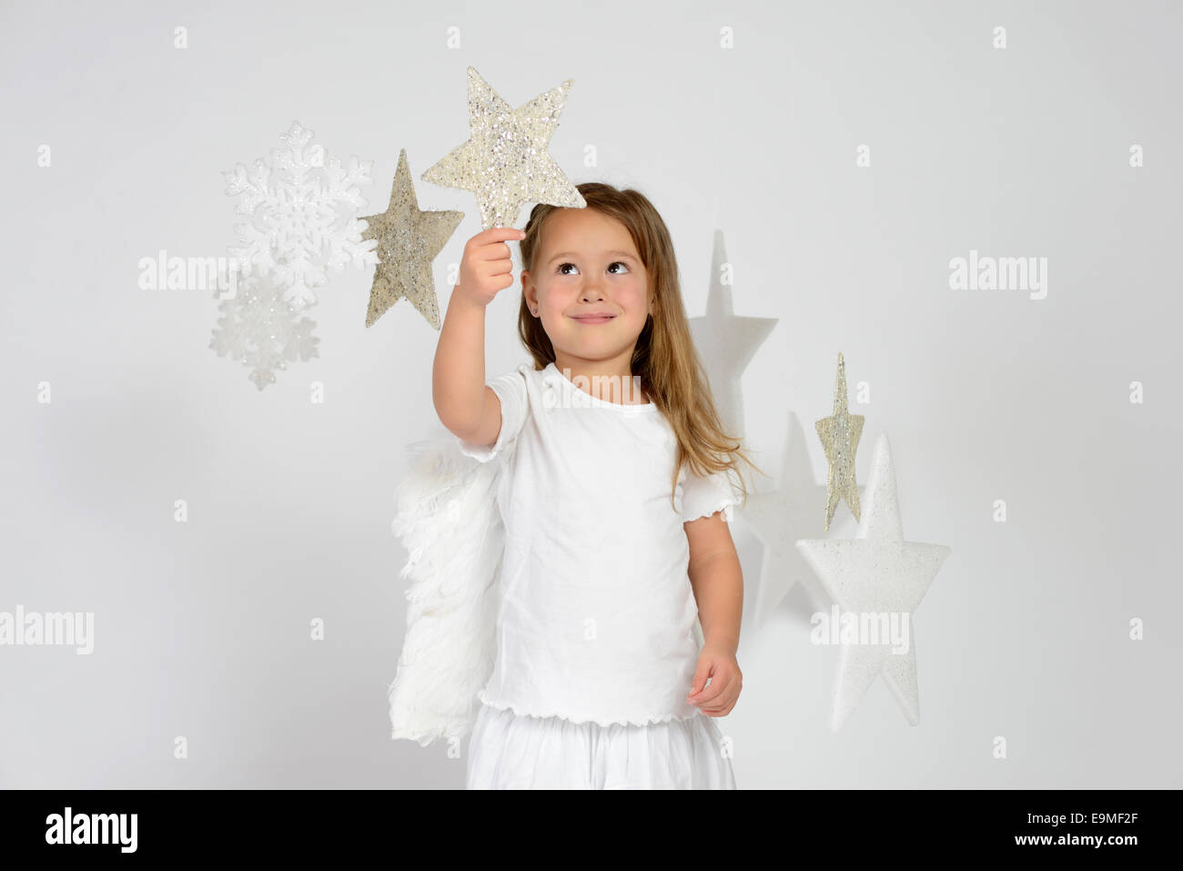 Bambino, ragazza che indossa un costume da angelo con stelle di natale, feste Foto Stock