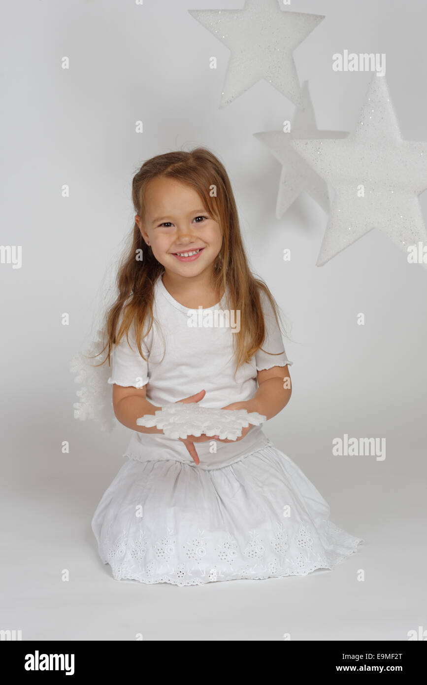 Bambino, ragazza che indossa un costume da angelo con stelle di natale, feste Foto Stock