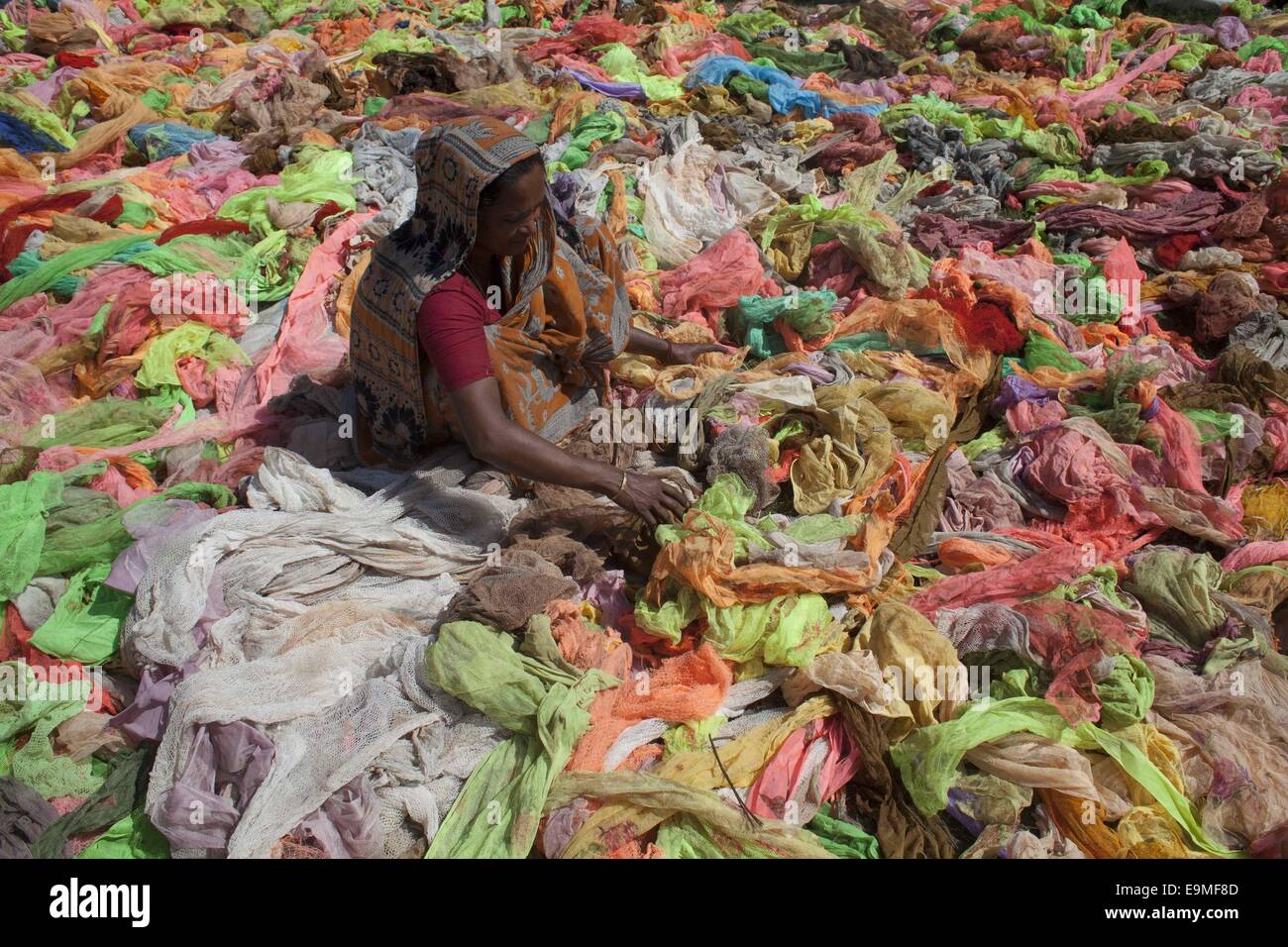 Dacca in Bangladesh. 30 ott 2014. Una donna di asciugatura panni utilizzabile sotto il sole raccolti dai rifiuti graments panni accanto a capi di abbigliamento di Dhaka. © Zakir Hossain Chowdhury/ZUMA filo/Alamy Live News Foto Stock